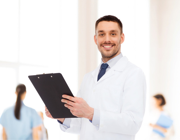 smiling male doctor with clipboard - Foto, imagen
