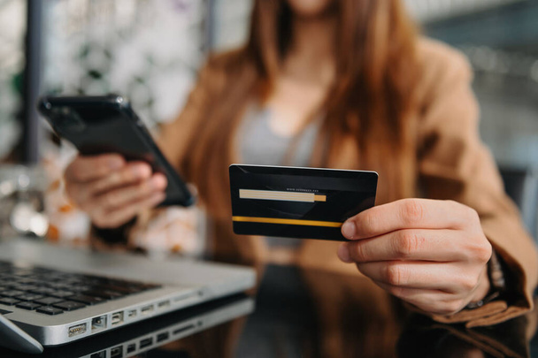 Woman hand holding credit card and using tablet ,laptop,online banking payment communication network, internet wireless application  - Fotoğraf, Görsel