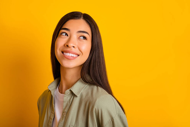 Portrait of positive pretty girl biting lips look interested empty space wonder isolated on yellow color background. - Fotoğraf, Görsel