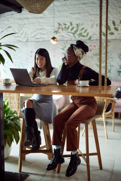 Dos alumnas multiculturales sentadas en la cafetería y estudiando para el examen. - Foto, imagen