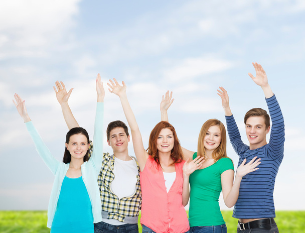 group of smiling students waving hands - Photo, image
