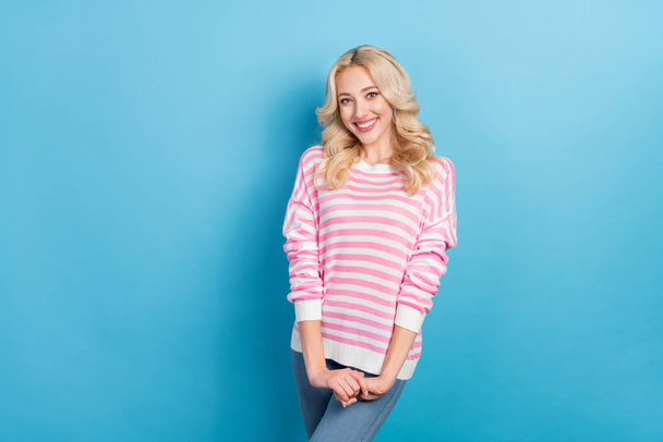 Photo of shy young blond hairdo lady hold palms wear pink shirt isolated on blue color background. - 写真・画像