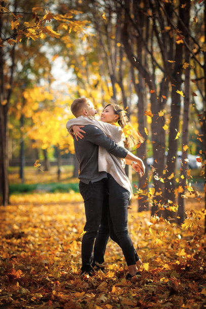 Romantic date in autumn park under leaf fall at sunset. - Photo, Image