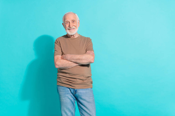Retrato de conteúdo atraente alegre homem de cabelos grisalhos dobrado braços espaço de cópia isolado sobre fundo de cor azul brilhante. - Foto, Imagem