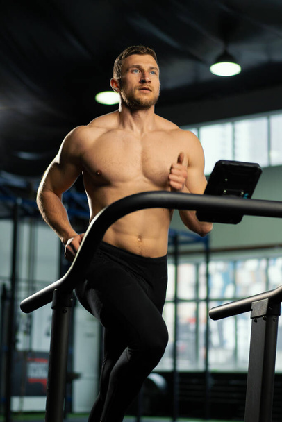 Male athlete running on a treadmill - Фото, зображення