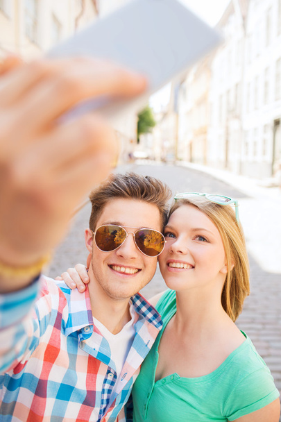 smiling couple with smartphone in city - Zdjęcie, obraz