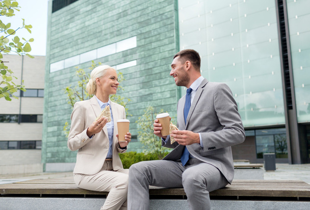 smiling businessmen with paper cups outdoors - Valokuva, kuva