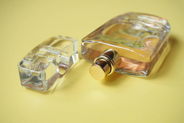 Primo piano di una bottiglia di profumo su fondo giallo. Vista dall'alto elegante composizione laconica con acqua aromatica (2) - Foto, immagini