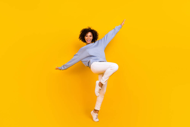 Full length photo of satisfied charming girl raise hands enjoy free time isolated on yellow color background. - Foto, imagen