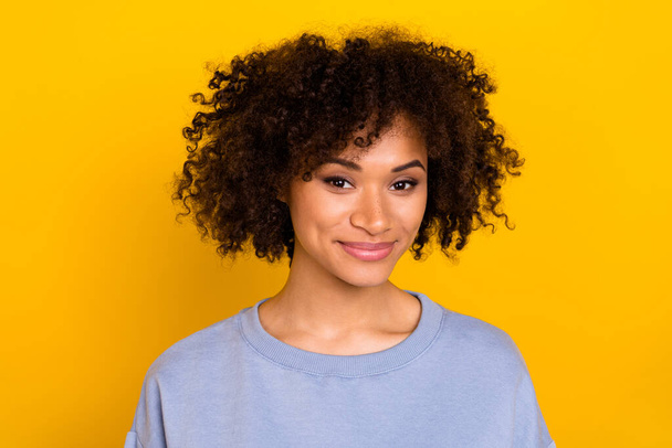 Photo of adorable sweet wavy lady wear blue sweatshirt smiling isolated yellow color background. - 写真・画像