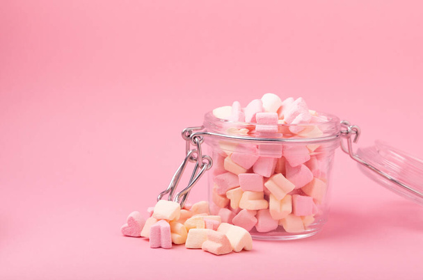 Marshmallow in a glass jar on a pink background. Fruit flavored sweets. Strawberry marshmallow.Copy space. Place for text - Фото, зображення