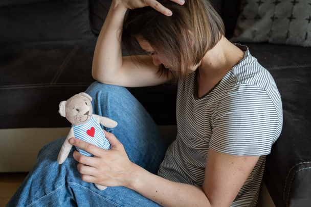 Perinatal loss reproductive chalenge concept - female holding a teddy bear toy. High quality photo - Zdjęcie, obraz