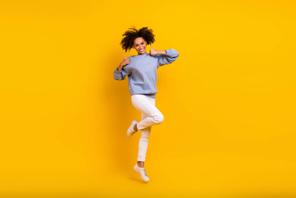 Full length photo of nice energetic girl jump hands fingers demonstrate thumb up isolated on yellow color background. - Фото, зображення