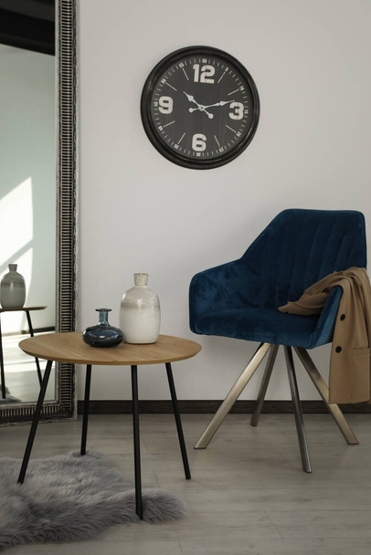 Room with wooden table and blue armchair. Stylish interior - Foto, afbeelding