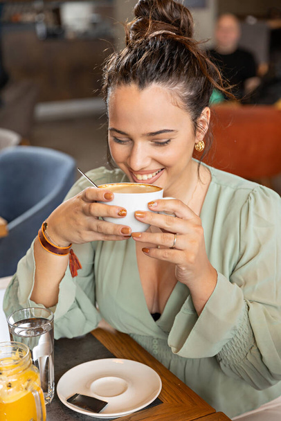 Beautiful woman drinking coffee in the cafe bar - Photo, image