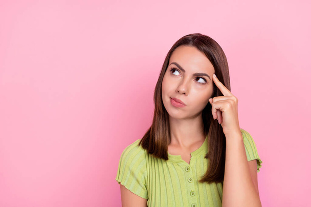 Photo of think brunette millennial lady look empty space wear green top isolated on pink color background. - 写真・画像