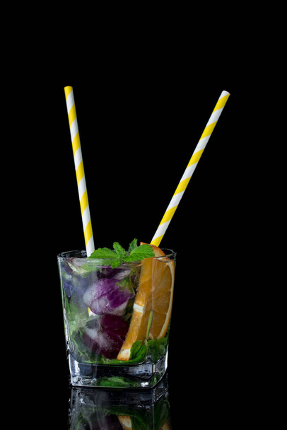 Glass with ice, cold water fresh mint and edible flowers  - Photo, Image