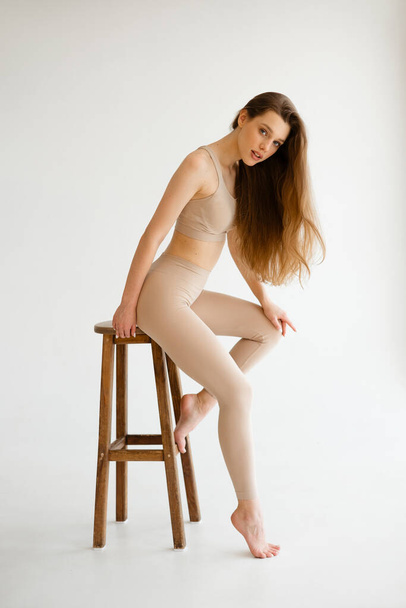 Beautiful girl with long hair in flesh-colored compression clothing. High quality photo - Valokuva, kuva