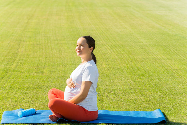 pregnant woman performs yoga asanas. High quality photo - Фото, изображение