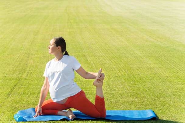 mujer embarazada realiza asanas de yoga. Foto de alta calidad - Foto, imagen