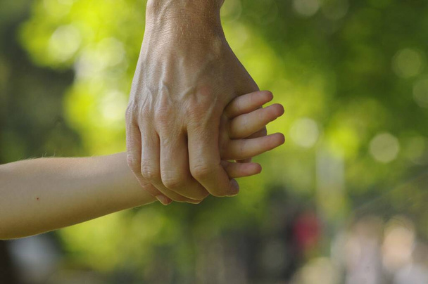 παιδί και μητέρα κρατώντας τα χέρια, σημάδι εμπιστοσύνης και οικειότητας - Φωτογραφία, εικόνα