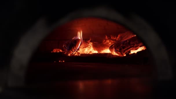 Tűzifa ég a sütőben. Hagyományos pizzasütő. Eredeti olasz sütő. Az eredeti pizza sütő lánggal a belsejében. - Felvétel, videó