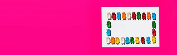 Flache Liege mit süßen Gummibärchen auf weißer und pinkfarbener Oberfläche, Banner  - Foto, Bild