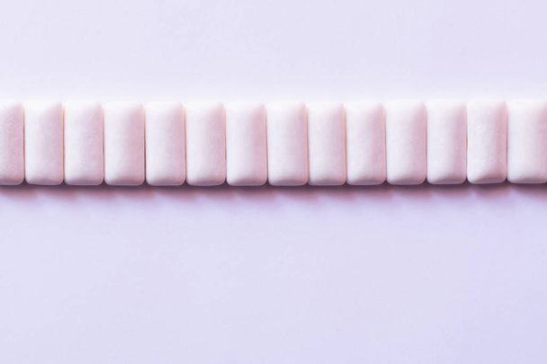 Flache Lage mit einer Reihe von Kaugummis auf weißem Hintergrund  - Foto, Bild