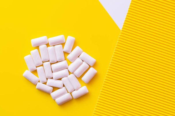 Top view of white chewing gums on yellow background  - Photo, Image