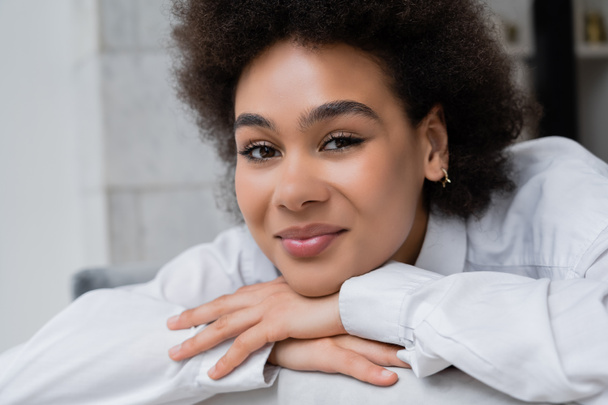 portrait of pleased and curly african american woman in white shirt with collar  - Photo, Image