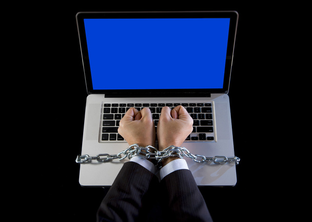 Руки бизнесмена, зависимого от работы, связаны цепью с компьютером ноутбуком у трудоголика
 - Фото, изображение