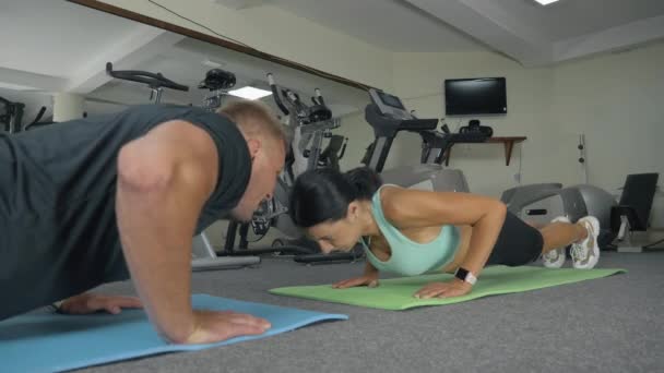 Спортивна жінка робить штовхання з тренером на тренувальному килимку. Молоді спортсмени тренуються у спортзалі
 - Кадри, відео