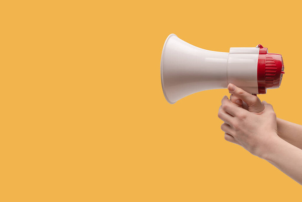 Megaphone in woman hands on a white background.  Copy space.  - Photo, Image
