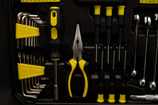 Caja de herramientas, varios dispositivos y tamaños, sobre fondo negro, plano detallado - Foto, imagen