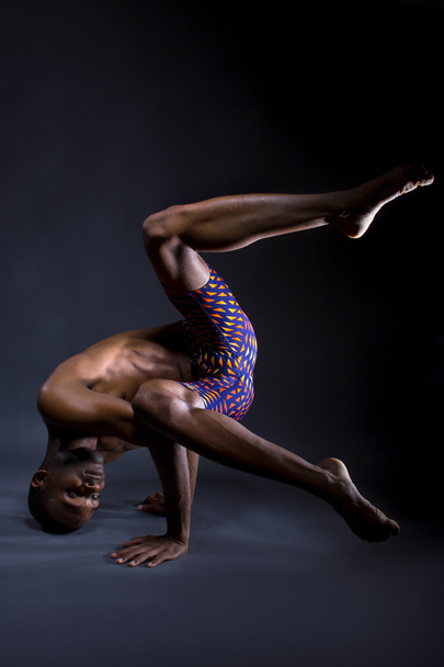 Black man doing upside down yoga - Фото, изображение