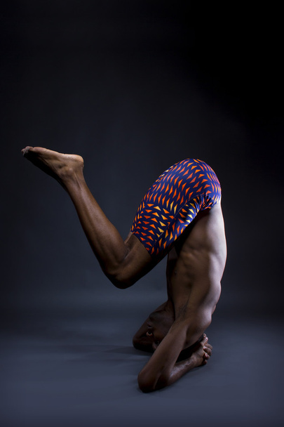Black man doing upside down yoga - Фото, изображение