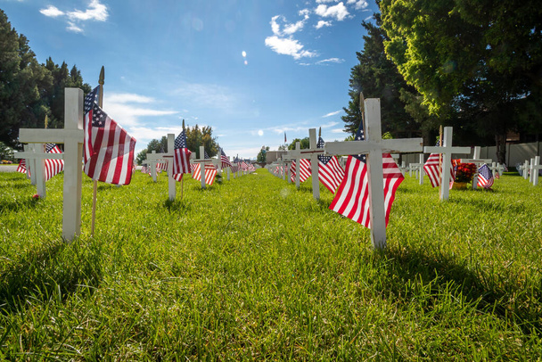 記念の日のためにアメリカの旗で飾られた軍事墓マーカー - 写真・画像