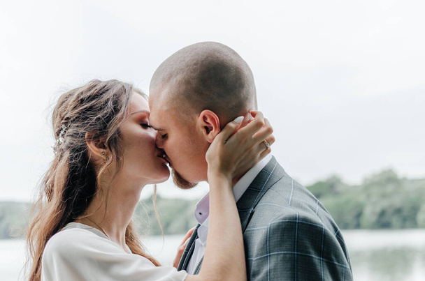 наречені цілуються на фоні озера
 - Фото, зображення