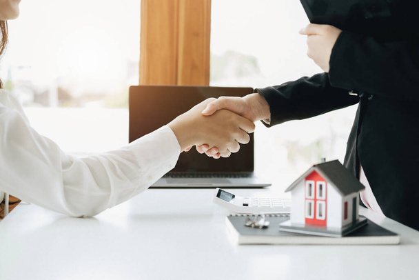 Гарантии, ипотека, подписи, страхование, договор, концепция договора, агенты по недвижимости пожимают руку клиентам, чтобы поздравить их после заключения сделки. - Фото, изображение
