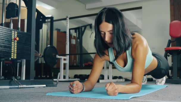Urheilullinen nainen tehdä perus vatsan vahvuus liikunta kuntosalilla. - Materiaali, video