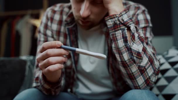 Mutsuz genç bir adam hamilelik testine bakıyor. Sevgilisinin hamileliğinden dolayı sorunları olan üzgün bir adam. Erkek, hamilelik testi sonucu yüzünden depresyonda. Bir daha baba olamadım..  - Video, Çekim