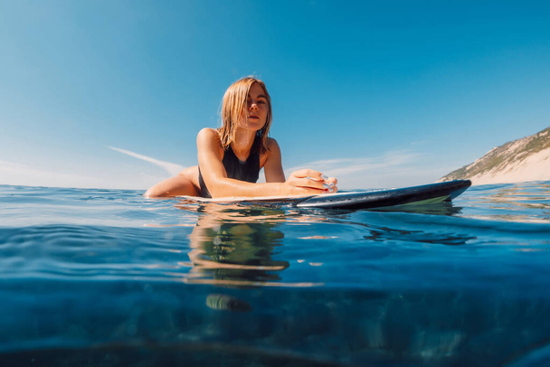Retrato de la joven rubia surfista en el océano durante el surf - Foto, imagen