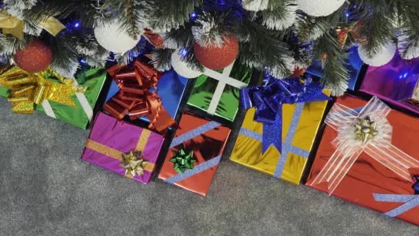 Weihnachtsbaum mit Geschenkschachteln und Geschenken herum. Geschmückter Neujahrsbaum. Nahtlose Schleife, Blick von oben - Filmmaterial, Video