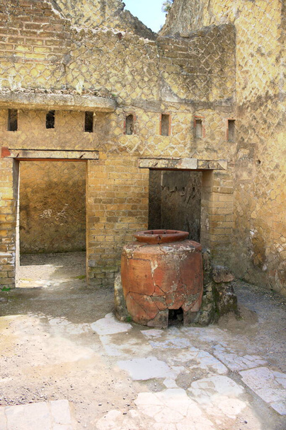 Herculaneum was an ancient city on the Gulf of Naples that sank like Pompeii, Stabiae and Oplontis during the eruption of Vesuvius in the second half of the year 79.This photo shows a house entrance with a large clay jug - Photo, Image