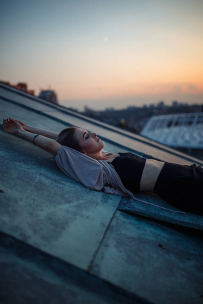 Young woman posing in the roof at sunset, freedom city atmosphere. People, lifestyle, relaxation concept. - Фото, изображение