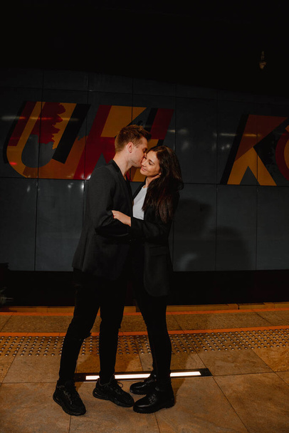 Под землей. Пара путешествует по новому городу вместе. Мальчик и девочка ждут поезда в метро. Подземное метро Варшавы. - Фото, изображение