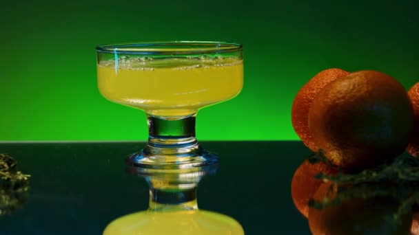 Nahaufnahme eines orangefarbenen Zitrusschaumgetränks im Cocktailglas in Zeitlupe. Aktienclip. Cocktail in der Bar, Theke mit Orangen dekoriert - Filmmaterial, Video