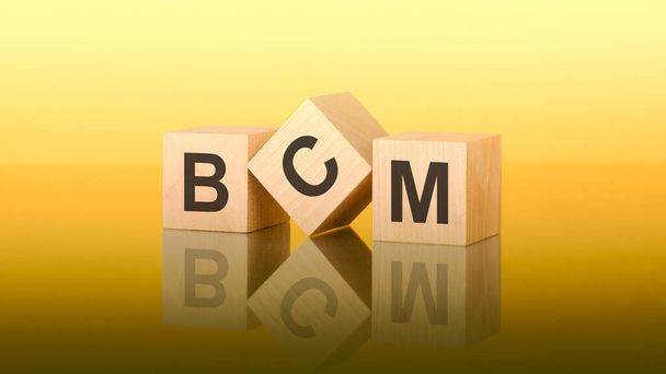 дерев'яні блоки з текстом AGM на жовтому фоні. bcm - короткий для управління безперервністю бізнесу - Фото, зображення