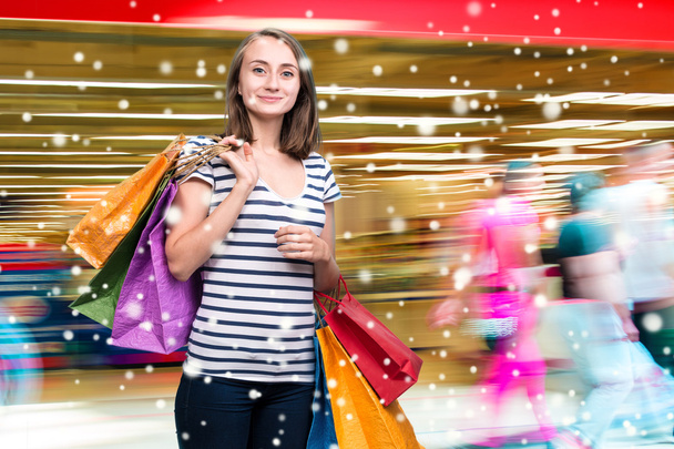 Молодая улыбающаяся девушка с сумками для покупок
 - Фото, изображение