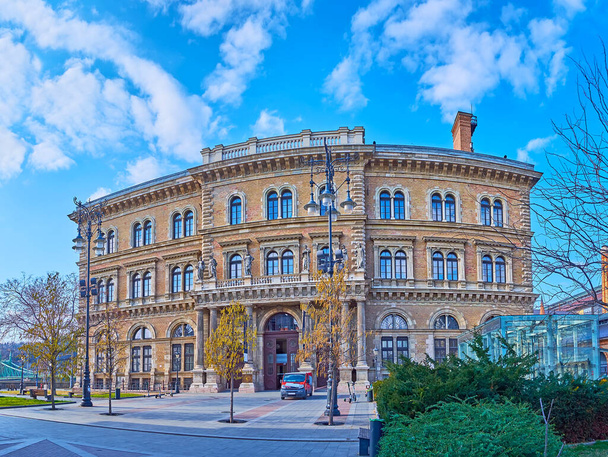Historic brick building of Corvinus University with carved stone decorations, columns and sculptures, Fovam Square, Budapest, Hungary - 写真・画像